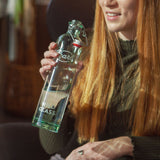 Photo of a woman drinking from a water bottle made in Europe named the Philos bottle